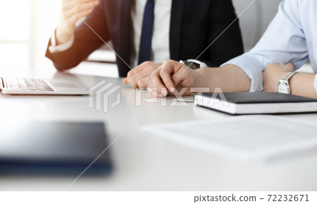 Unknown business people using laptop computer at the desk in modern office. Businessman or male entrepreneur is working with his colleague. Teamwork and partnership concept 72232671
