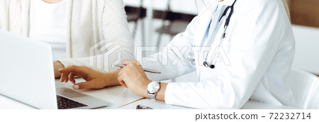 Unknown woman-doctor sitting and communicating with female patient. Physician checks medical history record and exam results, close-up. Healthcare concept Unknown woman-doctor sitting and communicating with female patient. Physician checks medical history record and exam results, close-up. Healthcare concept 72232714