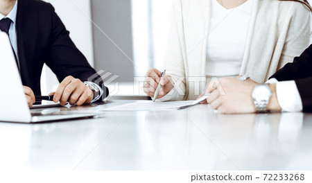 Business people discussing contract working together at meeting in modern office. Unknown businessman and woman with colleagues or lawyers at negotiation Business people discussing contract working together at meeting in modern office. Unknown businessman and woman with colleagues or lawyers at negotiation 72233268