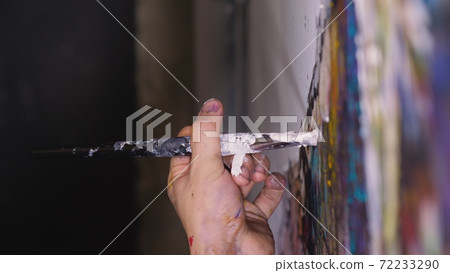 Artist designer draws an eagle on the wall. Craftsman decorator paints a picture with acrylic oil color brush. Close-up dark magic cinematic look. Artist designer draws an eagle on the wall. Craftsman decorator paints a picture with acrylic oil color brush. Close-up dark magic cinematic look. 72233290