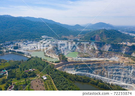 Aerial view of machine excavator trucks dig coal mining or ore with black grunge ground in quarry with mountain hills. Nature landscape background in factory industry. Environment resources 72233874