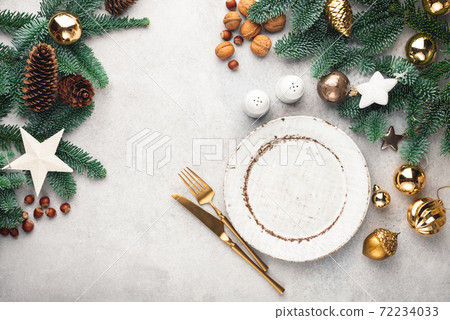 Christmas frame background with empty plate, golden cutlery and decorated fir tree Christmas frame background with empty plate, golden cutlery and decorated fir tree 72234033