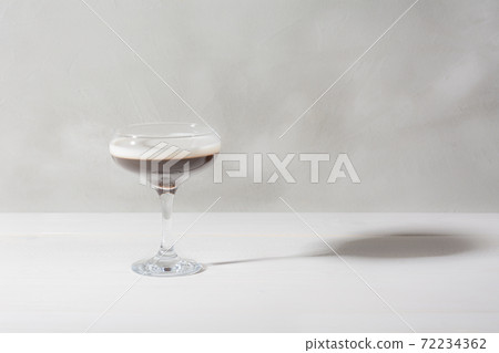 Jelly coffee with milk in a glass bowl in soft light. White background. Jelly coffee with milk in a glass bowl in soft light. White background. 72234362