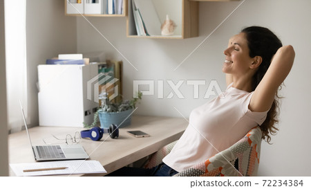 Close up smiling woman relaxing, stretching in comfortable chair 72234384