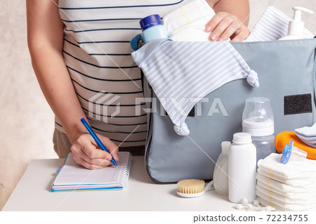 Woman packing diaper bag in maternity hospital. 72234755