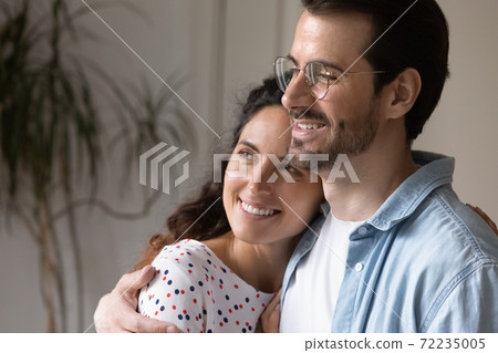 Close up dreamy young couple hugging, visualizing good future 72235005