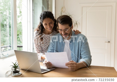 Happy wife and husband reading good news in letter Happy wife and husband reading good news in letter 72235030
