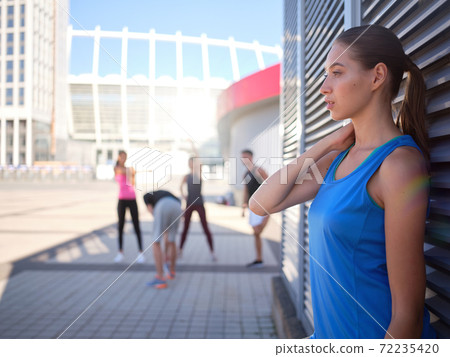 Young sportive caucasian woman leaning on wall Young sportive caucasian woman leaning on wall 72235420
