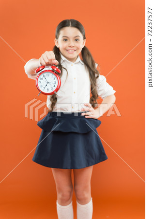 Schoolgirl child formal uniform hold alarm clock. Time to study. Schoolgirl child formal uniform hold alarm clock. Time to study. 72237577