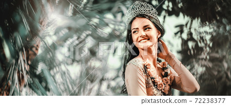 Woman with tiara on head posing in forest Woman with tiara on head posing in forest 72238377
