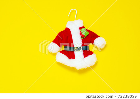 Christmas card. Santas red suit on yellow background Christmas card. Santas red suit on yellow background 72239059