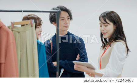 Young men and women choosing clothes 72240463