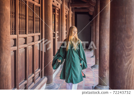 Woman tourist in national vietnamese dress in Temple of Literature in Hanoi in Southeast Asia, Vietnam. Vietnam reopens after coronavirus quarantine COVID 19 Woman tourist in national vietnamese dress in Temple of Literature in Hanoi in Southeast Asia, Vietnam. Vietnam reopens after coronavirus quarantine COVID 19 72243732