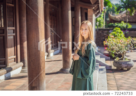 Woman tourist in national vietnamese dress in Temple of Literature in Hanoi in Southeast Asia, Vietnam. Vietnam reopens after coronavirus quarantine COVID 19 Woman tourist in national vietnamese dress in Temple of Literature in Hanoi in Southeast Asia, Vietnam. Vietnam reopens after coronavirus quarantine COVID 19 72243733