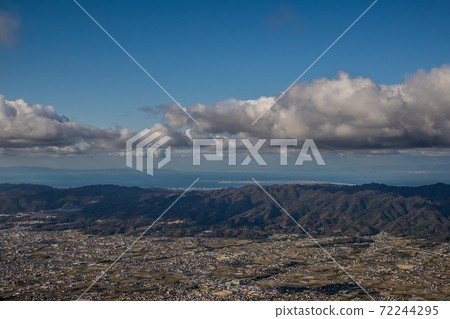 A paraglider flying toward the clouds boiling in the Izumi Mountains in the blue sky 72244295