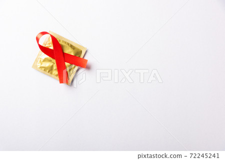 Red bow ribbon symbol HIV, AIDS cancer awareness and condom Red bow ribbon symbol HIV, AIDS cancer awareness and condom 72245241