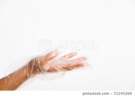 Woman hand wearing single use protect disposable transparent plastic glove 72245269
