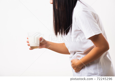 Woman use hand holding glass milk she is bad stomach ache 72245296