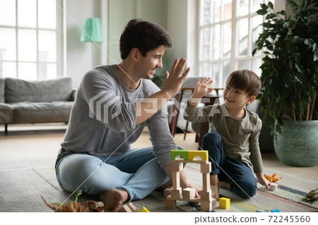 Happy young daddy giving high five to joyful small son. Happy young daddy giving high five to joyful small son. 72245560