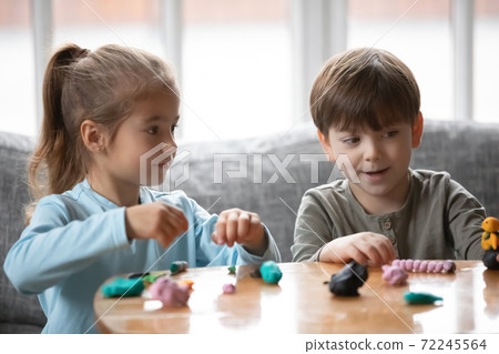 Joyful two cute little preschool children playing with playdough. Joyful two cute little preschool children playing with playdough. 72245564