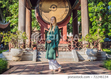 Woman tourist in national vietnamese dress in Temple of Literature in Hanoi in Southeast Asia, Vietnam. Vietnam reopens after coronavirus quarantine COVID 19 72246134