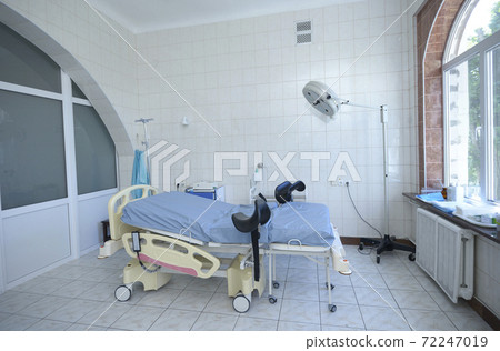 Delivery room of a maternity hospital, obstetric bed, lamp, medical equipment set 72247019