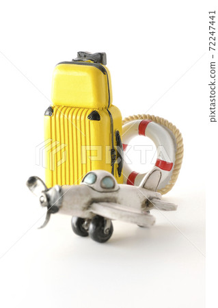 Taking a picture of a trip using a miniature model of an airplane or suitcase (white background) Taking a picture of a trip using a miniature model of an airplane or suitcase (white background) 72247441