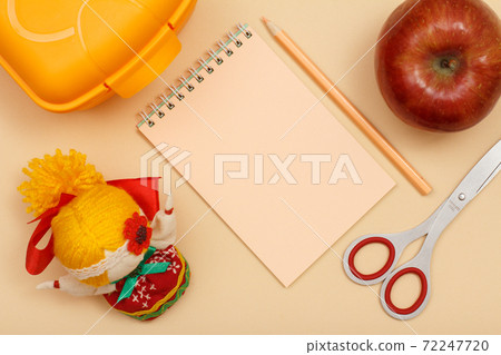 Notebook, scissors, apple and lunch box on beige background. 72247720