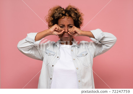 Desperate african woman puts her hands near eyes crying. Desperate african woman puts her hands near eyes crying. 72247759