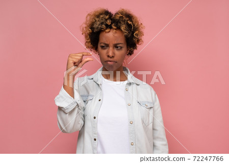 African young woman showing something small finger African young woman showing something small finger 72247766