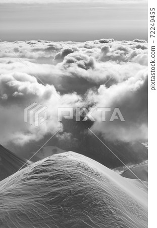 Snowy mountains in sunlight clouds at sun evening Snowy mountains in sunlight clouds at sun evening 72249455