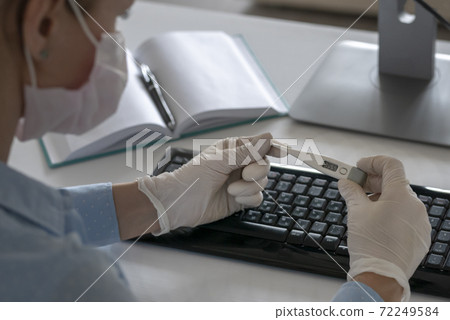Unrecognizable sick woman holding smartphone and thermometer in hands, working on a laptop home quarantine isolation Covid-19 pandemic Corona virus. 72249584