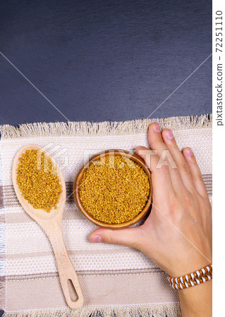 Fenugreek seeds in wooden bowl, spice, culinary ingredient, shamballa. vertical photo. copyspace Fenugreek seeds in wooden bowl, spice, culinary ingredient, shamballa. vertical photo. copyspace 72251110