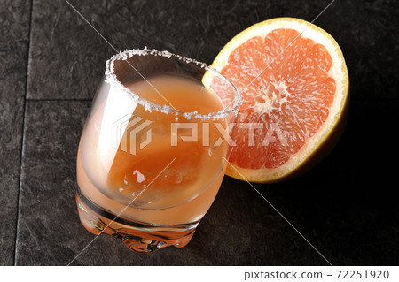 Pink salty dog with salt on the edge of the glass and cut grapefruit 72251920