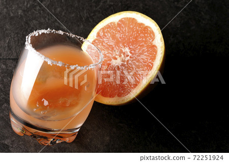 Pink salty dog with salt on the edge of the glass and cut grapefruit Pink salty dog with salt on the edge of the glass and cut grapefruit 72251924