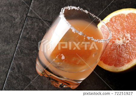 Pink salty dog with salt on the edge of the glass and cut grapefruit Pink salty dog with salt on the edge of the glass and cut grapefruit 72251927