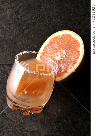 Pink salty dog with salt on the edge of the glass and cut grapefruit 72251929