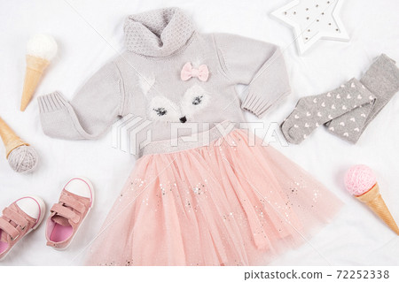 Set of casual child clothes, shoes and accessories on white background. Fashion girl lookbook consept. Knitted sweater, tulle skirt, sneakers, tights, ice cream cone. Top view, flat lay Closeup 72252338