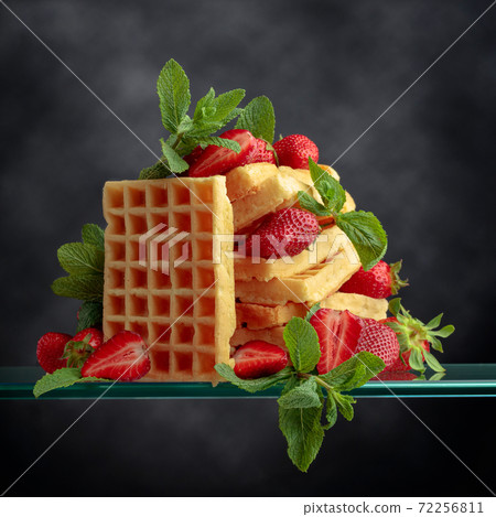 Waffles with strawberries and mint. 72256811