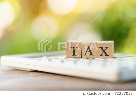 Pay Annual income (TAX) for the year on calculator. using as background business concept  72257032