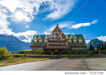 Prince of Wales Hotel in autumn sunny day morning. Blue sky, white clouds over mountains in the background. Landmarks in Waterton Lakes National Park, Alberta, Canada. Prince of Wales Hotel in autumn sunny day morning. Blue sky, white clouds over mountains in the background. Landmarks in Waterton Lakes National Park, Alberta, Canada. 72257398