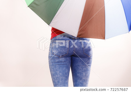 Woman standing under multicolored umbrella Woman standing under multicolored umbrella 72257687