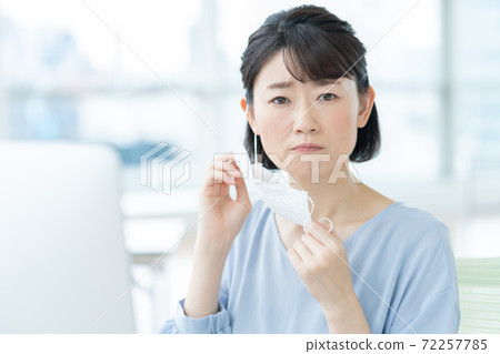 一個女人因為辦公室裡的面具而擔心皮膚粗糙 一個女人因為辦公室裡的面具而擔心皮膚粗糙 72257785