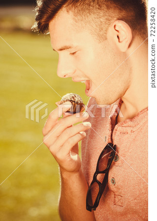 Smiling man with cookie. Smiling man with cookie. 72258420
