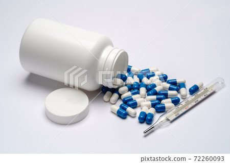 Medications capsules in a bottle and thermometer on light grey background 72260093