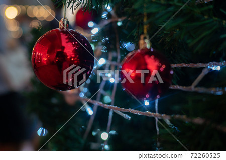 Close up of vintage toned red balls on christmas tree bokeh garlands in the background. Close up of vintage toned red balls on christmas tree bokeh garlands in the background. 72260525