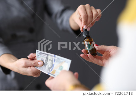Womens hands transferring money and collecting marijuana extract closeup 72261718