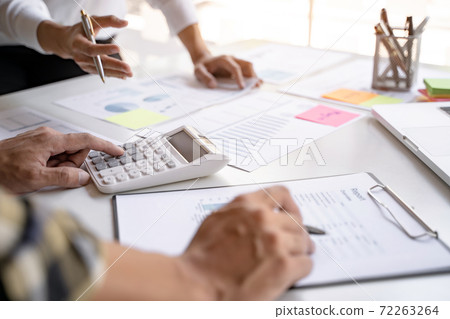 Financial inspector calculating a numbers in office room.. Financial inspector calculating a numbers in office room.. 72263264