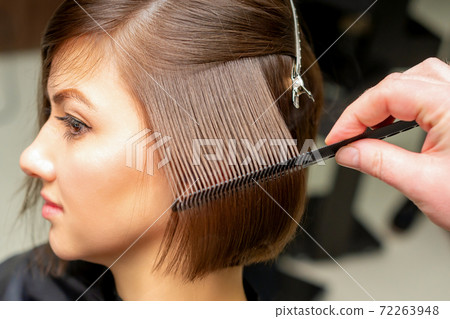 Hairdresser brushing straight female hair 72263948