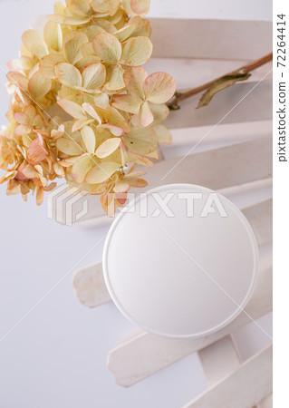 white cosmetics container and hydrangea inflorescence on a white background. Health, body care 72264414